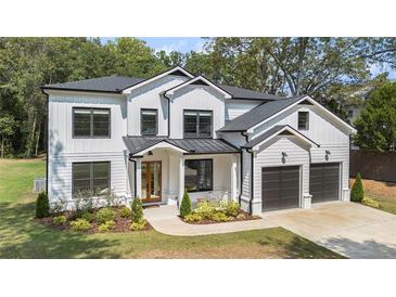New two-story home with manicured landscaping, a two car garage and dark framed windows at 396 Academy St, Alpharetta, GA 30009