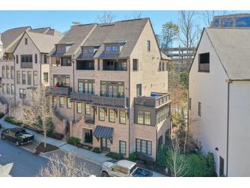 Charming brick townhome with multiple balconies and a well-maintained landscaped front yard at 6601 Cadence Blvd, Atlanta, GA 30328