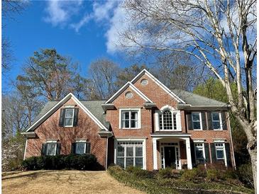 Charming two-story brick home featuring a manicured lawn and complemented by mature trees at 272 Lynshire Sw Ct, Marietta, GA 30064