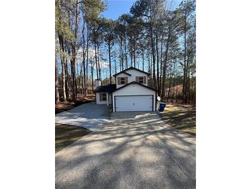 Charming two-story home with a two-car garage and fresh landscaping at 5075 Forest Downs Ln, Atlanta, GA 30349