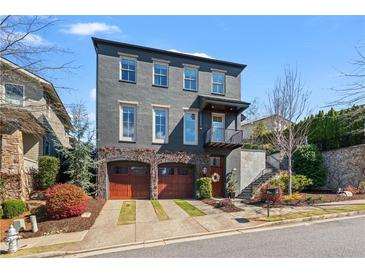 Stunning three-story home featuring a two-car garage and beautiful landscaping at 6845 Wesley Hughes Rd, Cumming, GA 30040