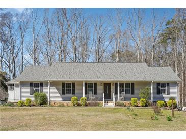 Charming single-story home featuring a cozy front porch, gray siding and well-maintained landscaping at 9991 Holly Hill Way, Jonesboro, GA 30238