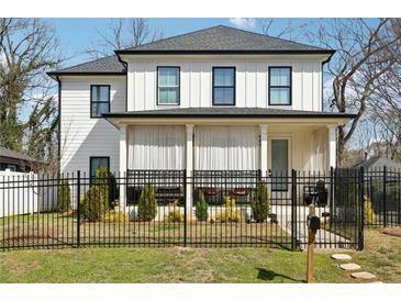 Charming two-story home featuring a well-manicured lawn and black metal fencing at 969 Parsons Sw St, Atlanta, GA 30314