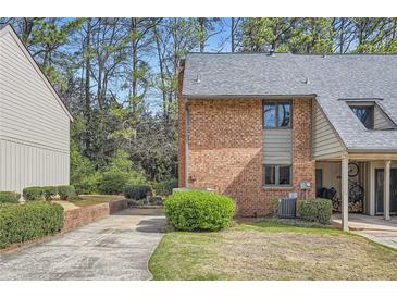 Brick exterior featuring a carport, well-maintained lawn, and mature landscaping at 2459 Cedar Canyon Se Ct, Marietta, GA 30067