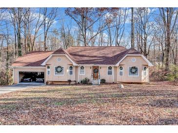 Charming ranch home with a tan exterior, wreaths on the windows, and an attached two car garage at 9224 Snipe Ln, Jonesboro, GA 30236