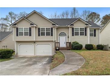 Charming split-level home with manicured lawn, two-car garage, and inviting front porch at 174 Whetstone Way, Villa Rica, GA 30180