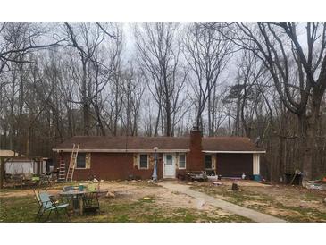 Quaint brick single-story home featuring mature trees, a lawn, and inviting front entrance at 111 Oak Grove Rd, Temple, GA 30179