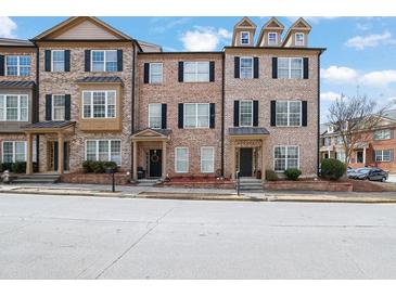 Charming brick townhome featuring black shutters and well-maintained landscaping at 1952 Appaloosa Mill Cir, Buford, GA 30519
