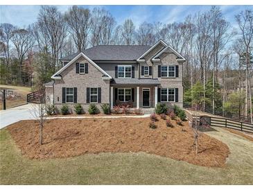 Beautiful two-story brick home with black shutters and a well-manicured lawn on a sunny day at 3878 Amicus Dr, Buford, GA 30519