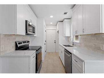 Bright kitchen features white cabinets, stainless steel appliances, and stone countertops at 5225 Maple Valley Sw Rd, Mableton, GA 30126