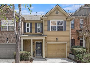 Charming two-story townhouse featuring neutral siding, black shutters, and a one-car garage at 2728 Keystone Gates Ct, Lithonia, GA 30058