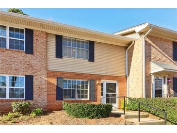 Two story townhouse with brick and beige vinyl siding and dark shutters on a sunny day at 386 Northdale Ct, Lawrenceville, GA 30046