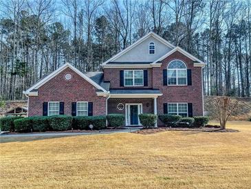 Charming brick two-story home with manicured landscaping and black shutters against a background of mature trees at 1763 Emerald Dr, Jonesboro, GA 30236