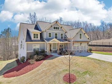 Charming two-story home featuring a blue exterior, a two-car garage and a well manicured lawn at 110 Canyon Ridge Trl, Canton, GA 30114