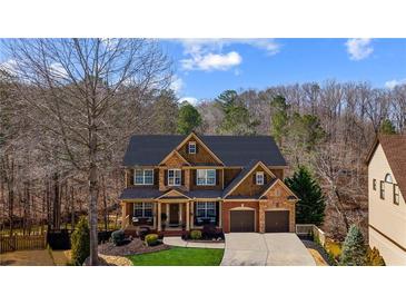 Beautiful two-story home with stone and wood accents, a covered front porch, and a well-manicured lawn at 172 Knightwood Point, Acworth, GA 30101