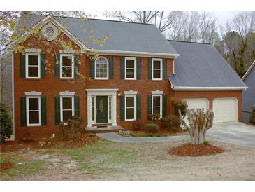 Charming two-story brick home with a well-manicured lawn, dark green shutters, and a two-car garage at 179 Hunters Crk, Dallas, GA 30157