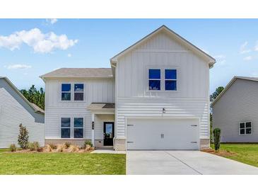 Charming two-story home featuring a modern facade, well-manicured lawn, and attached two-car garage at 213 Groveton Ct, Euharlee, GA 30145