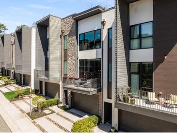 Modern townhome with mixed materials, a balcony, and a gray garage door and walkway at 103 Birch St, Decatur, GA 30030