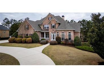 Beautiful two-story brick home featuring a well-manicured lawn and elegant landscaping at 912 Fire Thorn Dr, Hampton, GA 30228