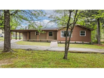 Charming single-story home featuring a covered parking area and a well-maintained front yard at 3951 Covered Bridge Sw Rd, Smyrna, GA 30082