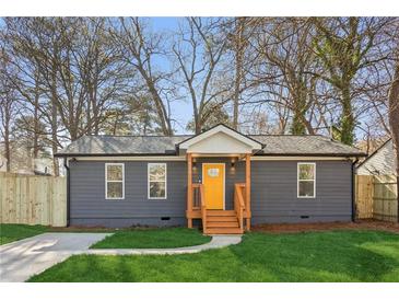 Charming home featuring a newly landscaped yard, gray siding, and a welcoming bright yellow front door at 4179 Hanes Dr, Decatur, GA 30035