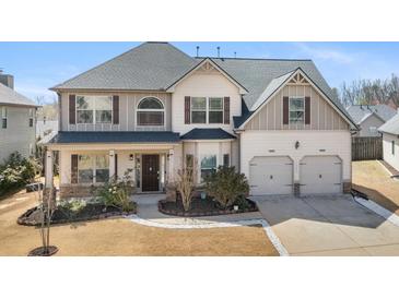 Charming two-story home featuring a well-manicured lawn and an inviting front porch at 1645 Renfroe Run, Cumming, GA 30041