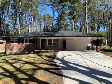 Beautiful brick home featuring a long driveway and a spacious carport at 4430 Locksley Rd, Tucker, GA 30084