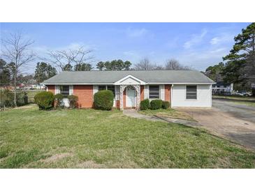 Charming one-story home featuring a brick facade, well-maintained lawn, and mature landscaping at 5205 Dunmoreland Ct, Atlanta, GA 30349