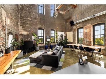 Expansive living room features exposed brick walls, large windows, and modern decor at 170 Boulevard Se # H523, Atlanta, GA 30312
