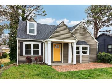 Charming home featuring a bright yellow front door, a brick walkway, and well-manicured lawn at 2654 Jefferson Ter, Atlanta, GA 30344