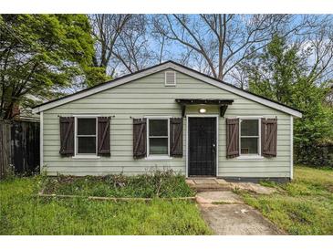 Quaint, single-story home featuring light green siding, dark shutters, and a simple covered porch at 3020 Harold Se Ave, Atlanta, GA 30316