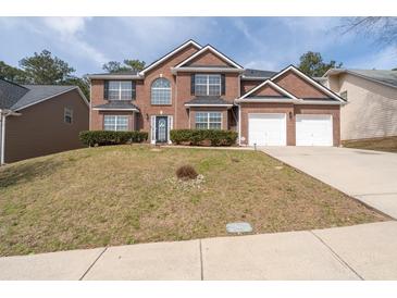 Beautiful two-story brick home featuring a two-car garage and well-manicured lawn at 7178 Cavender Sw Dr, Atlanta, GA 30331