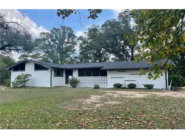 Charming single-story home with white painted brick and mature trees at 1027 Goza Rd, Fayetteville, GA 30215
