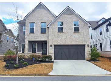 Charming two-story brick home featuring an attached two-car garage and manicured front yard at 1116 Heatherland Dr, Marietta, GA 30066