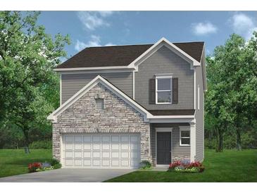 Charming two-story home with stone accents, gray siding, a two-car garage and manicured front lawn at 712 Shetland Trl, Cartersville, GA 30121