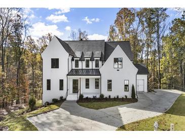 Beautiful two-story home with black trim windows, neutral paint, and a spacious driveway at 128 Owens Mill Pl, Canton, GA 30115