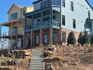 Home with a covered porch and brick foundation, landscaped hillside at 1919 Repose Dr, Chamblee, GA 30341