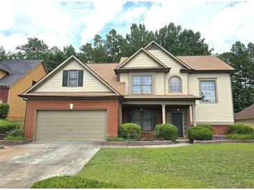 Charming two-story home with a brick and siding exterior, well-manicured lawn, and attached two-car garage at 3070 Ridge Oak Dr, Suwanee, GA 30024