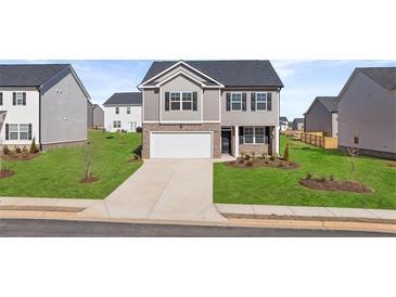 Charming two-story home with a well-manicured lawn and a two-car garage at 169 Aster Avenue, Locust Grove, GA 30248