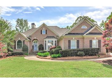 Charming brick home featuring a well-manicured lawn and landscaped front yard with a welcoming entrance at 8155 Legends View Ct, Cumming, GA 30028