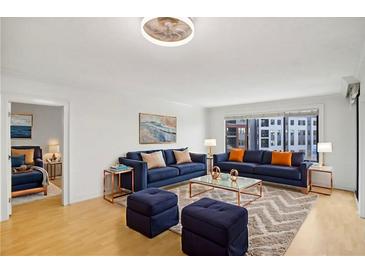 Bright living room with modern furniture, stylish rug, and large windows overlooking city views at 3481 Lakeside Ne Dr # 807, Atlanta, GA 30326