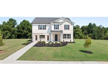 Charming two-story home boasts a lush lawn and a classic white brick and vinyl facade at 640 Kimberwick Dr, Locust Grove, GA 30248