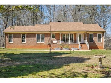Charming single-story brick home featuring a cozy front porch and well-maintained lawn at 9975 Holly Hill Way, Jonesboro, GA 30238