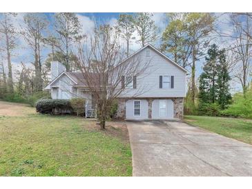 Charming two-story home featuring light gray siding, stone accents, and a well-manicured front lawn at 6405 Grafton Dr, Austell, GA 30168
