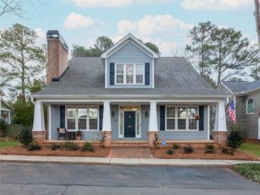 Charming home with a brick chimney, a cozy front porch, and manicured landscaping at 3036 Lassiter Rd, Marietta, GA 30062