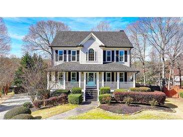 Charming two-story home with a covered front porch and manicured landscaping at 1712 Green Farm Cir, Dacula, GA 30019