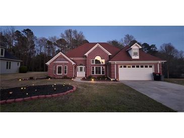 Charming brick home featuring a landscaped front yard and an attached two-car garage at 460 Greystone Ln, Douglasville, GA 30134