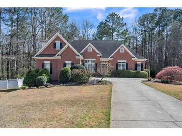 Beautiful brick home with a well-manicured lawn and a long driveway leading to the front entrance at 1490 Highland Lake Dr, Lawrenceville, GA 30045