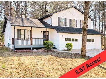 Charming two-story home featuring a covered porch, a two-car garage, and a well-manicured lawn at 6730 Alvan Ct, Riverdale, GA 30296