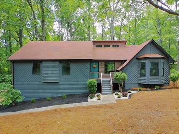 Charming home with teal door, lovely landscaping, and a wooded view at 4843 Caboose Nw Ln, Acworth, GA 30102